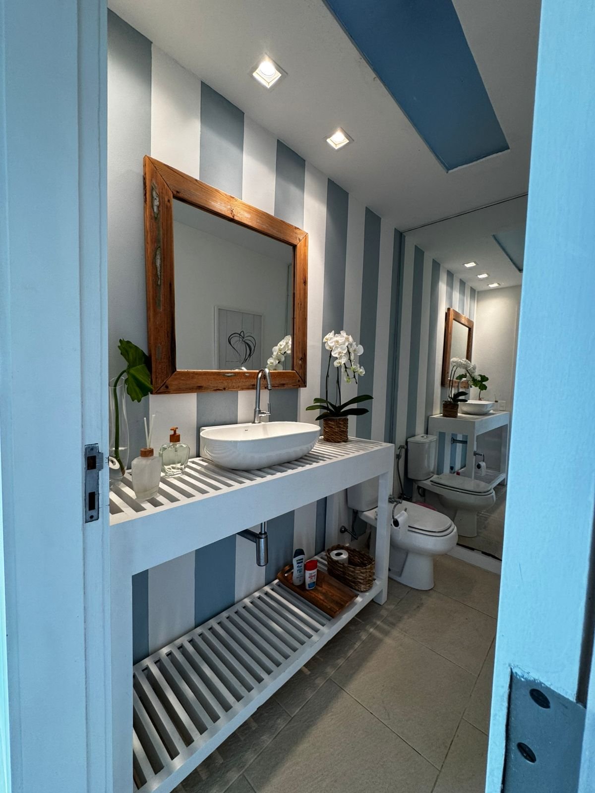 Lavabo com listras azuis e moldura de madeira
